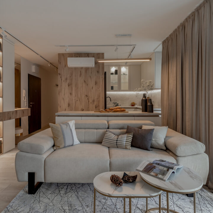 Salon połączony z kuchnią w mieszkaniu w Warszawie, czytelny układ i stonowana kolorystyka – Ursus